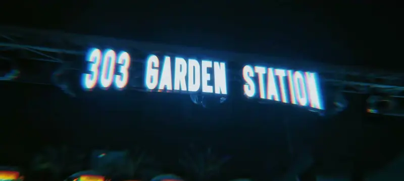 Dòng chữ 303 GARDEN STATION phát sáng trên giàn thép của khu vườn về đêm